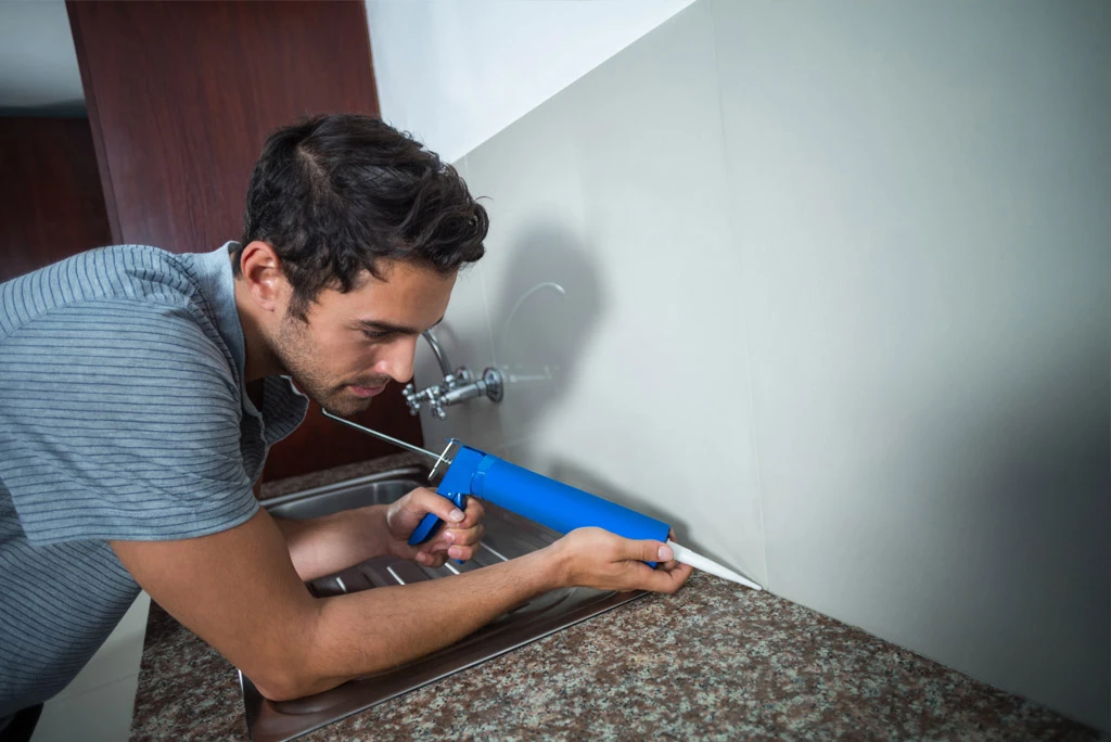 man filling cracks on wall
